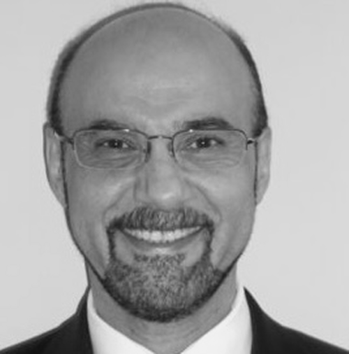 Headshot of Hassan Serhan, PhD a man with glasses and beard smiling straight on.